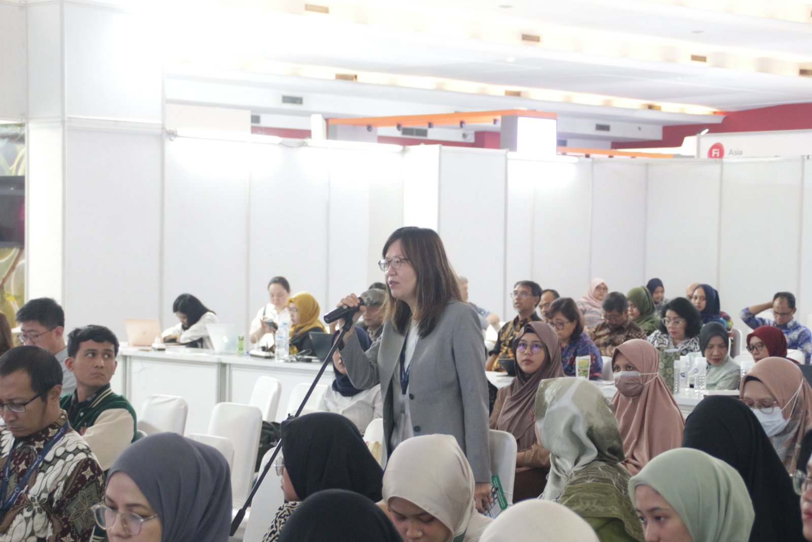 Speaker presenting to a full audience during a technical session